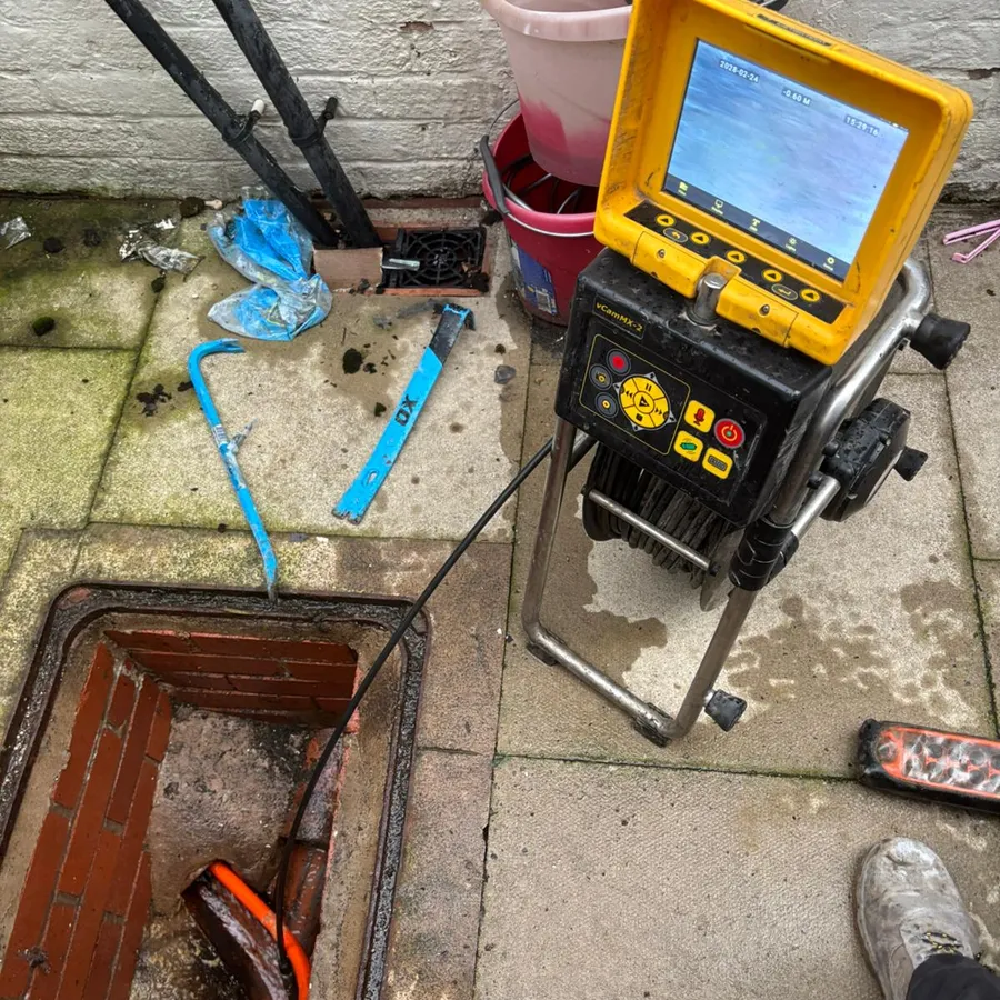 CDS engineer running a vCam CCTV drain survey at an open inspection chamber
