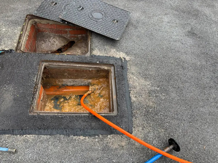 The opened manhole with the jetting hose on Browsholme Avenue, Burnley