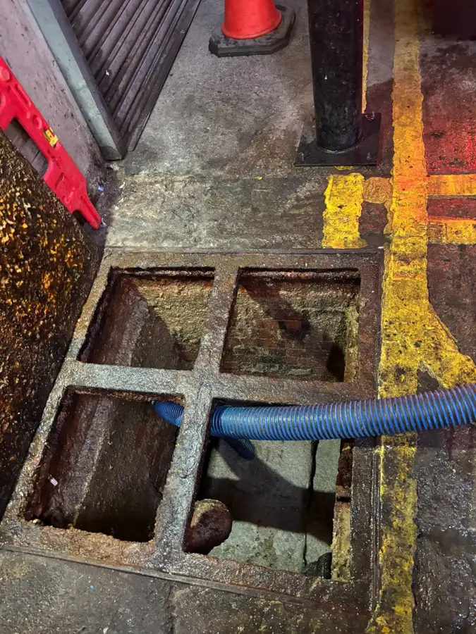 The fat trap being emptied with a suction hose at a food market in Burnley